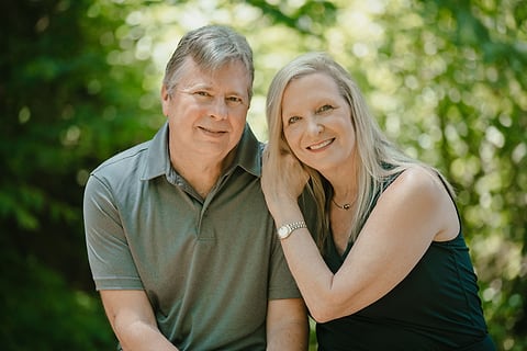 Married couple cheek to cheek in a green garden
