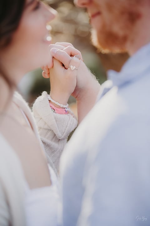 Engagement ring detail as a couple holds hands