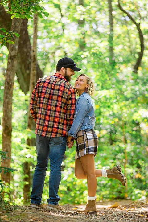 Playful kiss with a lifted foot in the forest