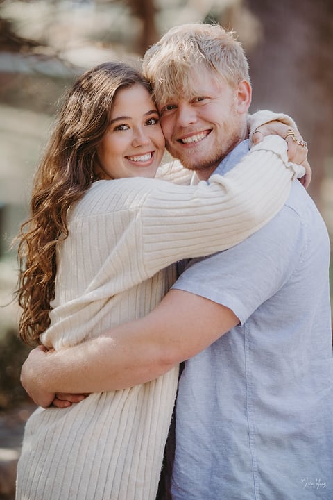 Couple hugging and smiling outdoors in the fall
