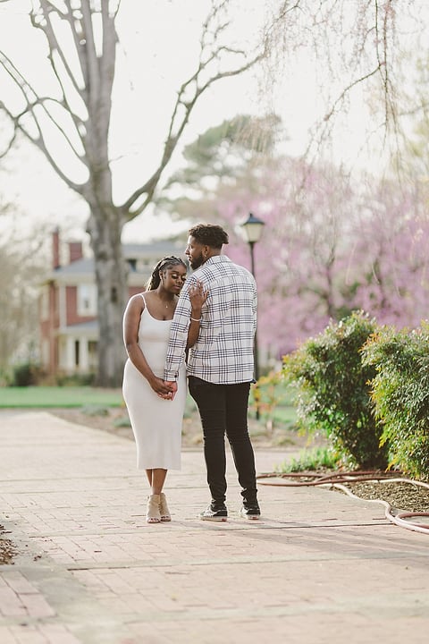Couple walking hand in hand along a garden path in spring