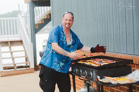 Cookout host grilling at a community event