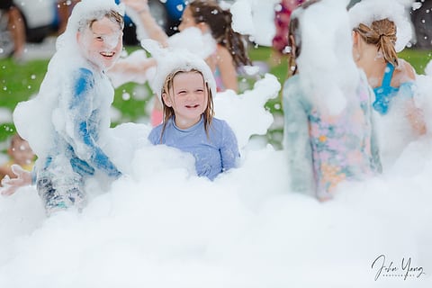 Children playing in foam at a summer event