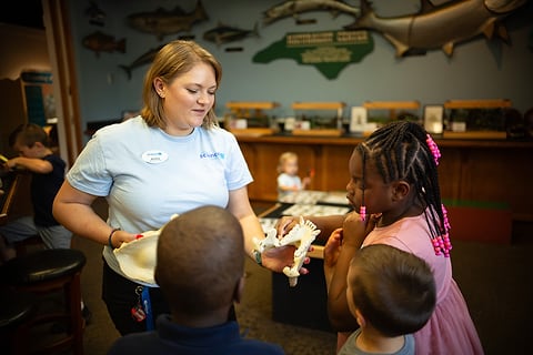 Kids exploring a museum exhibit with a guide