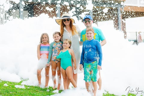 Family posing in the foam at a summer party