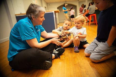 Children gathered around an educator on the floor