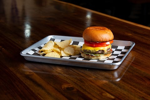 Cheeseburger and chips on a checkered tray