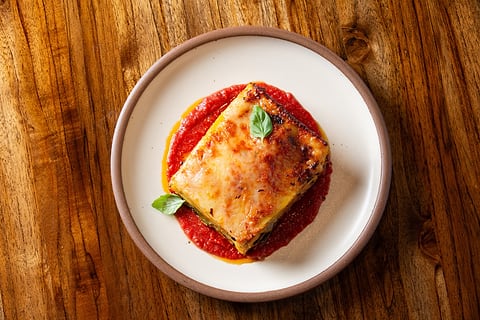 Plated lasagna with red sauce, shot from above