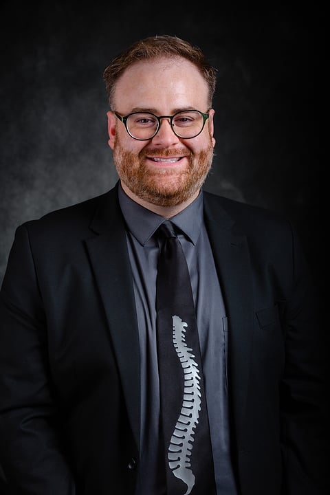 Studio headshot of a professional on a dark backdrop