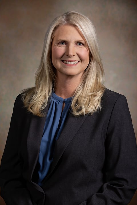 Corporate headshot of a woman on a painted backdrop