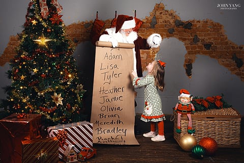 Girl checking Santa's list in a festive studio set