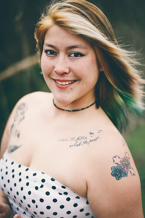 Model with tattoos and a polka-dot top