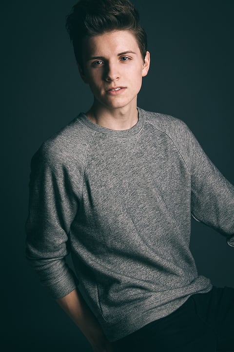 Model in a gray sweater on a dark backdrop