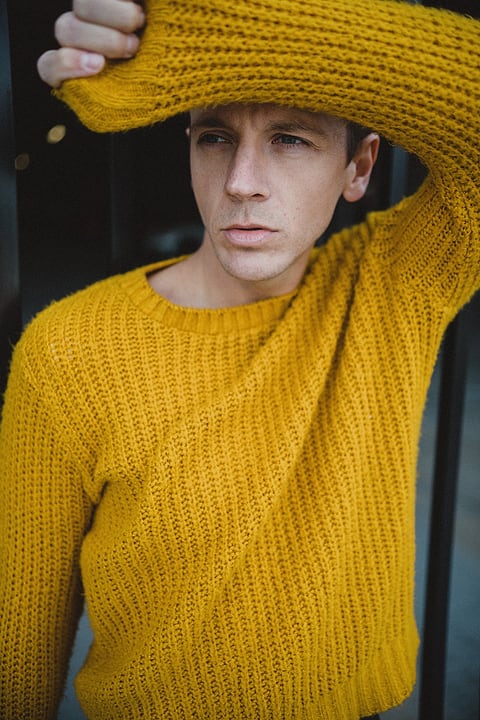 Model in a mustard knit sweater