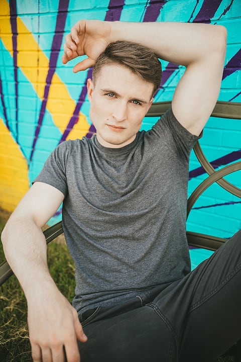 Model posing in front of a colorful mural
