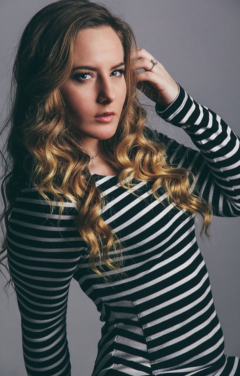Model with curly hair in a striped dress