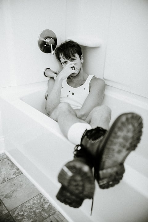 Black and white editorial portrait in a bathtub