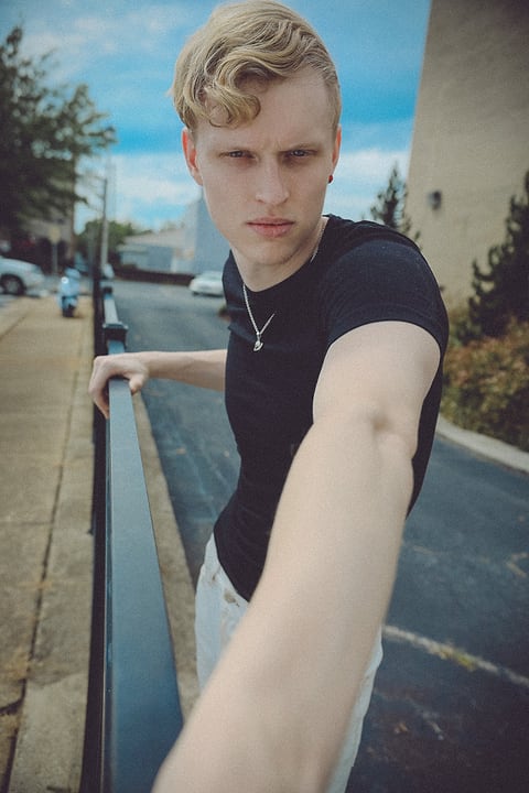 Blonde male model on a city sidewalk