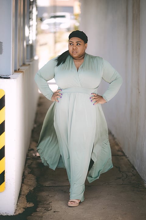 Model in a mint dress in a sunny hallway