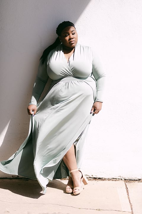 Model in a flowing dress against a white wall