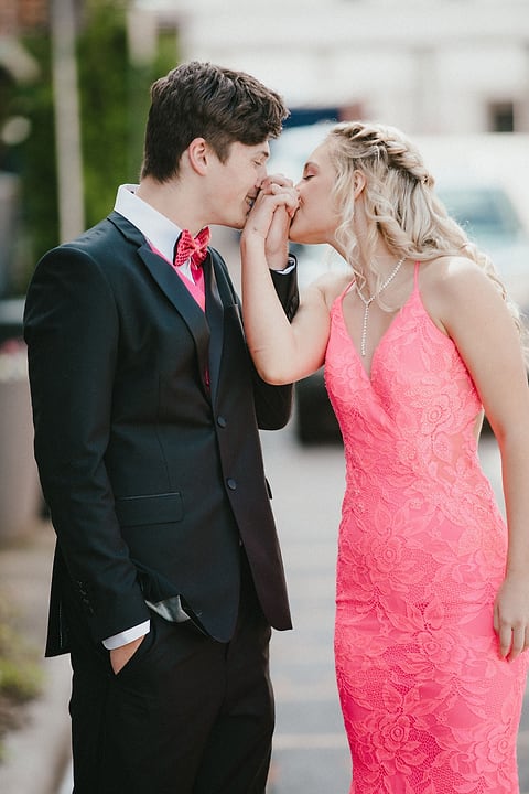 Prom date kissing his date's hand downtown