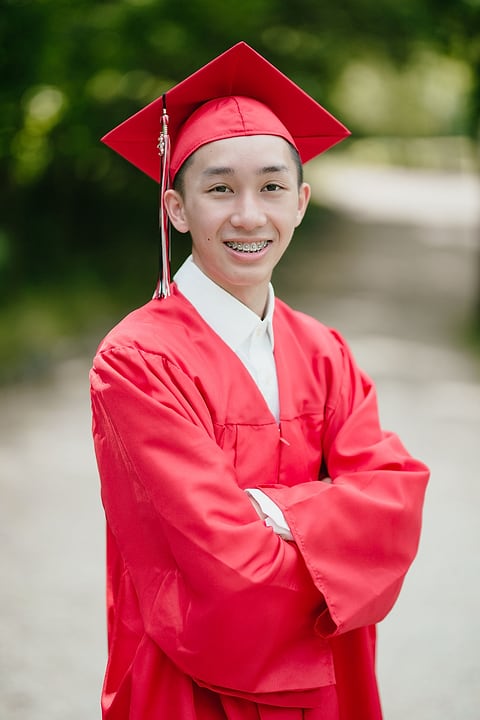 Smiling graduate in a red cap and gown