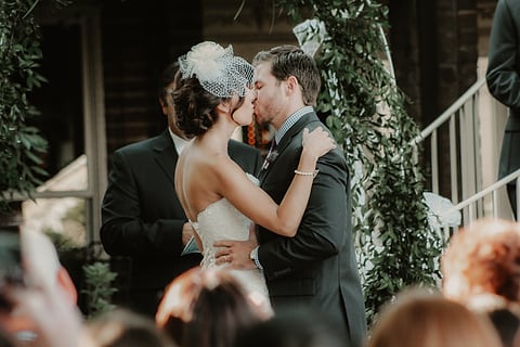 Couple's first kiss at their outdoor wedding ceremony